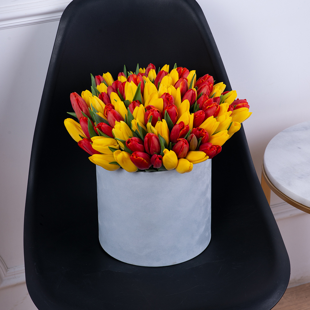 Букет из 101 разноцветного тюльпана в серой бархатной шляпной коробке